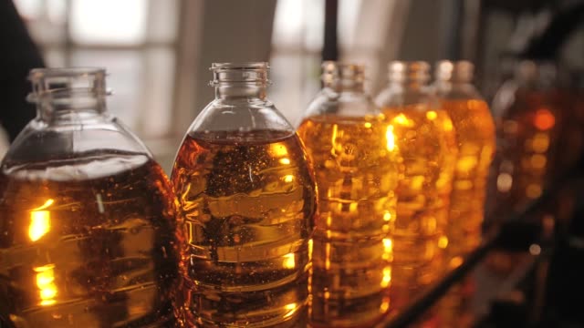 Bottles of sunflower oil moving through the pipeline. Close-up of bottles.